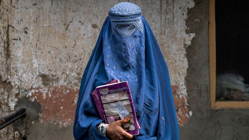 Arefeh 40-year-old, an Afghan woman leaves an underground school, in Kabul, Afghanistan, Saturday, July 30, 2022. She attends this underground school with her daughter who is not allowed to go to public school. For most teenage girls in Afghanistan,